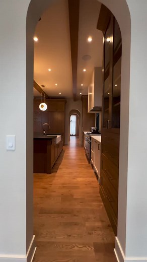As you transition from the mudroom through this stunning kitchen, the arched openings guide your journey with an inviting elegance. Custom cabinetry lines the way, offering both beauty and practicality, while the marble counters add a touch of timeless luxury. Passing by the butler’s pantry and food pantry, each detail has been carefully crafted to ensure perfection. The journey culminates in the dining room, where these thoughtful designs connect every space seamlessly, making this home truly e