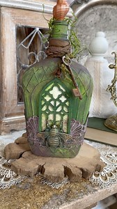 19K views · 279 reactions | A couple new Altered Art bottles are in the shoppe today! My canvas were two old whisky bottles and I’ve turned them into enchanting works of art, each holding a tiny watercolor painting inside a miniature cathedral window. I just love bringing these to life. #enchanted #alteredart #bottleart #upcycledart #fairybottles Find these at: https://thevintageangelllc.etsy.com | The Vintage Angel | Facebook