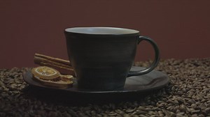 Pouring coffee in a cup among many coffee beans - Free Stock Video