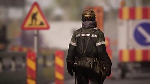 CGI Worker in safety gear walking through construction site with warning signs