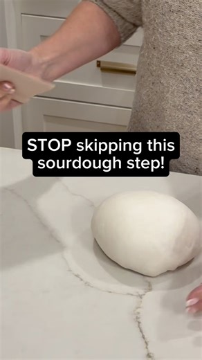 LINK for the pink dough scraper I’m using is in the comments 💗👇 This is how I preshape my sourdough (and yes, it’s a step you really don’t want to skip). I use the straight edge of my dough scraper to gently push the dough down and under itself as I move in a slow counter-clockwise motion. My other hand just acts as a guide to help keep things tidy and round. That simple motion starts building surface tension before the final shape, which is what helps your loaf hold its structure, rise tall i