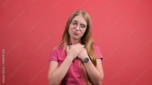 Omg, it is incredible. Happy cheerful female model with joyful expression, cheers and celebrates her success, has appealing look, poses against red background.