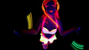 female disco raver girl poses in UV costume with spinning led poi lights