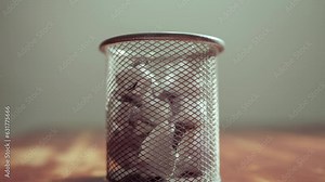 Stop motion of trash bin full of crumpled paper