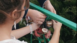 The decorative lock in hands of newlyweds. Clip. Wedding symbol of everlasting love, lock in hands of bride and groom
