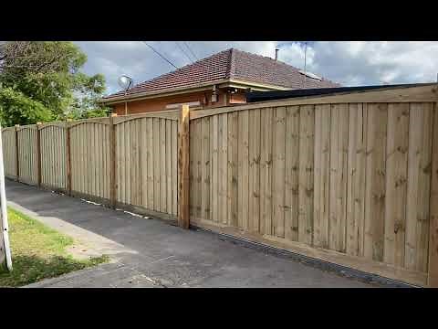 Exposed post paling fence with arched header board and automatic sliding gate