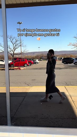 Stylish Woman in Dark Dress Walking by Parking Lot