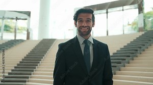Smart business man looking at camera while standing at stairs. Closeup of successful man smiling at camera while wearing business suit. Executive manager look at camera. Moving camera. Exultant.