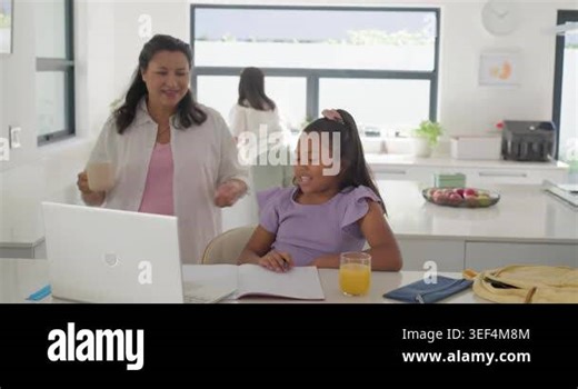 African American family with Asian woman guiding after girl gesturing at notebook on kitchen island. Home, homework, learning, collaboration, parent, child, device Stock Video Footage - Alamy