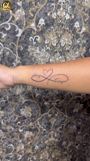 A beautifully delicate infinity tattoo featuring a heart at the center, symbolizing endless love and connection. The design is personalized with the names “Vikraj” and “Trishiya,” making it a timeless tribute to a bond that lasts forever. #InfinityTattoo #LoveTattoo #CoupleTattoo #NameTattoo #HeartTattoo #ForeverLove #TattooDesign #PersonalizedTattoo #MinimalTattoo #FineLineTattoo #TattooInspiration #TattooArt #TattooLovers #CoupleGoals #InkCulture | Athokpam ink