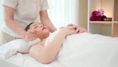Young Asian woman getting spa massage with Thai Herbal Ball Hot...