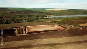 Engineering , construction innovations, Aerial view of the rainwater retention basin construction, extreme wide above drone shot moving slowly from right to left toward, excavator cranes working