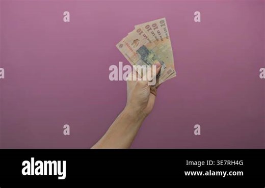 Man holding romanian leu banknotes with a pink background, highlighting the currency and isolated setting Stock Video Footage - Alamy