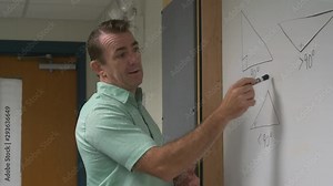 Man teaching math, angles, triangles, in a classroom on a board in front of a class.