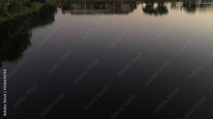 Aerial reveal two people in a johnboat fishing on a city lake at sunset, South Florida