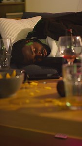 Vertical Video Of Man Lying Passed Out Asleep On Sofa After Drinking Alcohol At House Party Suffering With Hangover | Free Stock Video Footage