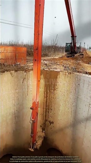 Cet engin lourd extrait efficacement les matériaux du fond d'une immense fosse cylindrique.