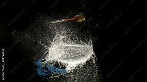 Dart pops water balloon, slow motion