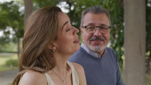 A mature couple sits closely on a park bench, sharing a lovely conversation at the park - Free Stock Video