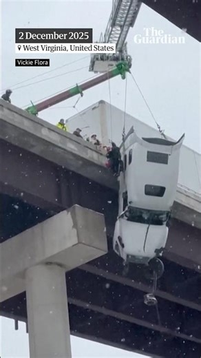 Driver rescued from truck dangling from side of bridge as heavy snowfall hits US
