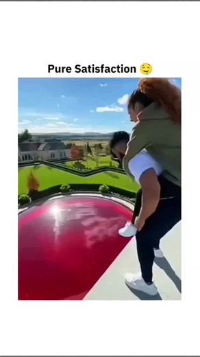Flashy on Instagram: "The video features a stunning 15-second satisfying clip where a duo takes a leap of faith onto a massive, translucent red dome that looks like a giant pool of jelly. Set against a luxury estate, the footage reveals how a high-tension gelatinous surface reacts to human impact—and the visual result is nothing like what people expect. As they land, the camera captures deep, hypnotic ripples flowing across the crimson surface, proving just how elastic and surreal these large-sc