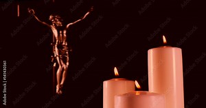 Video footage of three candles light and a christian cross symbol
