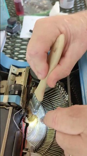 Maintenance workshop: Cleaning inside an Olivetti typewriter.