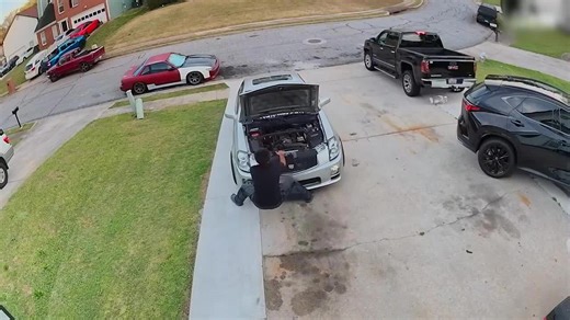 Car Rolls Down Driveway as Man Works on Engine