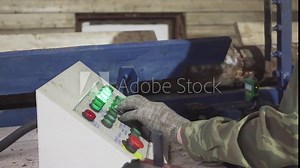The operator gives the commands to wood cutting machine. Close up