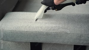 Refreshing sofa and cushions from dust and dirt with dry-cleaning extractor 4k video. Extracting dust and dirt, removing spots from sofa using extractor to clean upholstered furniture.