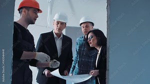 The builder measuring the doorway while talking to the managers and supervisor about the blueprint. Group of quality control weared hard hat and suit checks the sizes and quality of the performed