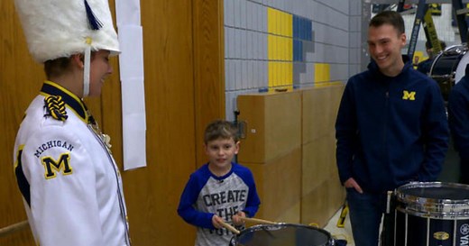 Boy surprised by Michigan marching band
