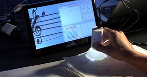 Handheld device scans and plays sheet music