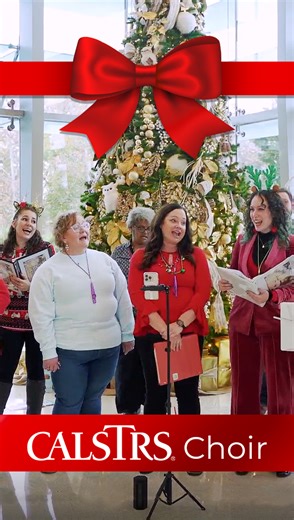 The CalSTRS choir brought holiday cheer to the headquarters lobby in West Sacramento during their lunch break performances this week. The group, comprised of active, retired, and former CalSTRS staff members, performed seasonal songs at both 100 and 200 Waterfront Place. They are scheduled to perform next week at the Capitol Rotunda in Sacramento. We appreciate their efforts in spreading joy this festive season. alt text: Video showing people singing Happy New Year in front of a large Christmas 