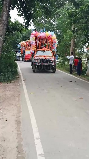 Colorful Vehicle Procession with Balloons and Garlands