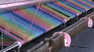 Loom at a textile factory. Fabric production line. A close up of weaving machine. Weaving machine for garment industry. Yarn thread lines on the weaving loom machine for clothing in textile factory Stock Video