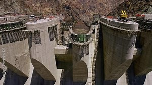 The video shows the ongoing construction of a large dam, featuring significant progress in the structure, with workers and large machinery actively operating on site.