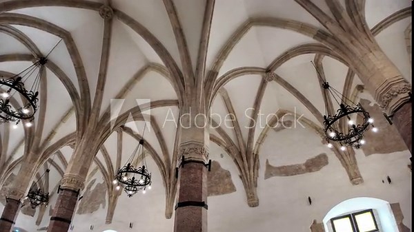 Corvin Castle's interior showcasing the vast great hall with multiple octagonal columns, impressive vaulted ceilings, and remnants of old frescoes on ancient walls in Hunedoara, Romania Transylvania