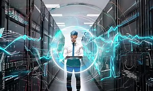 Technology officer using laptop in large data center with digital channel through server