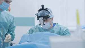 Operation of removing tonsils under deep anesthesia, surgeon uses latest devices, cold plasma method, cuts swelling in throat, doctor works with new probe, medical headlamp, surgical loupes