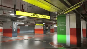 The car is heading towards the exit from the parking garage. Garage of a shopping mall or business center.