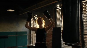 A young strong female boxer in the boxing ring. Concept of training, victory competition and professional sports. Self-defense, girl power, girl power and combat training, feminism.