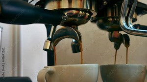 Coffee extraction from the coffee machine with a portafilter pouring coffee into a cup, Espresso pouring from the coffee machine at coffee shop