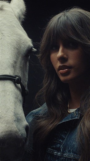 Our Denim Darling, Ella Langley, surrounded by denim and dandelions 🌼🐎👖🌾 shop now 🔗 https://american-eagle.visitlink.me/bSAkbw | American Eagle