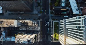 Aerial overhead view of main shopping street in Chicago. Skyscrapers with rooftops. Urban grid with cars. Morning light