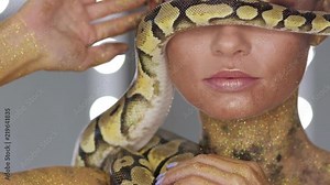Woman with body art holding snake