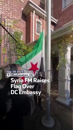 Syrian Foreign Minister Asaad al-Shibani raises his country’s flag over the embassy building in the US capital Washington. | Al Arabiya English