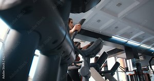 Low angle view. Female athletes in the gym. Group of attractive girls perform exercises on simulators. Treadmill, running, steps, walking , calf muscles, hips. 50 FPS slow motion. Tracking shot