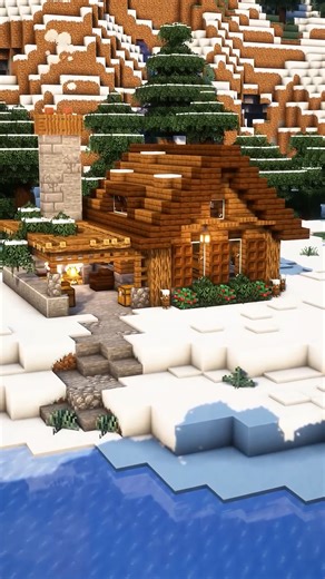 This Minecraft cabin uses warm lighting to create a calm snowy atmosphere