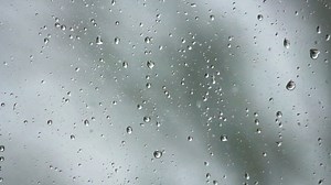 drops of rain running down the glass